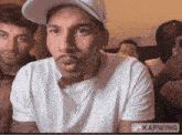 a man wearing a white hat and a necklace is being edited by kapwing