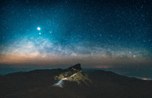 a starry night sky over a mountain