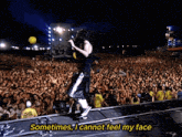 a man singing into a microphone in front of a crowd with the words " sometimes i cannot feel my face "