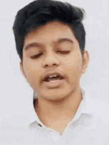 a close up of a young man 's face with his eyes closed and his mouth open .