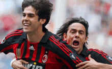 two soccer players wearing adidas jerseys are hugging and smiling