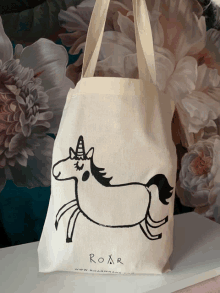 a tote bag with a drawing of a unicorn and the word roar on it