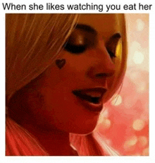 a close up of a woman 's face with a heart on her cheek and when she likes watching you eat her .