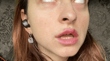 a close up of a woman 's face with earrings on her ear