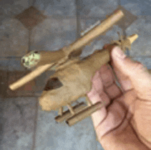 a person is holding a small helicopter made out of a cigarette .