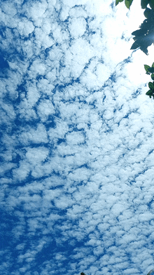 a blue sky with white clouds and the sun shining through them