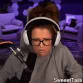 a woman wearing headphones and glasses with the words sweettails on the bottom right
