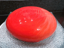 a red ball is sitting on top of a glass plate