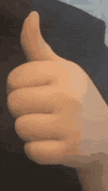 a close up of a person giving a thumbs up sign