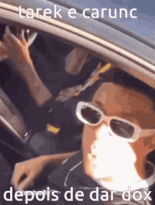 a man wearing sunglasses and a mask is driving a car with a caption .