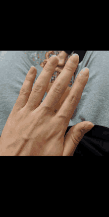 a person 's hand with a ring on it