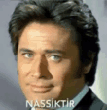 a close up of a man 's face with the word nassiktir on the bottom right