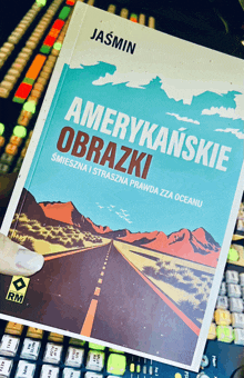 a book titled amerykańskie obrazki by jasmin sits on top of a keyboard