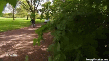 a person riding a bike down a dirt path with the words " die neue wache " on the bottom left