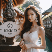 a woman in a white dress stands in front of a sign that reads balon 168