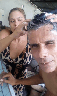 a woman washing a man 's hair with a brush