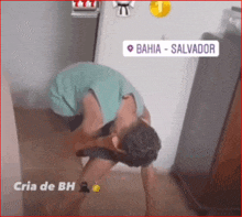 a man kneeling down in front of a refrigerator that says bahia-salvador