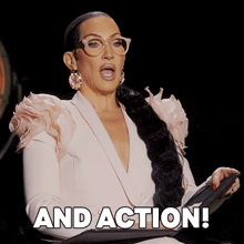 a woman wearing glasses holds a clipboard with the words and action written on it