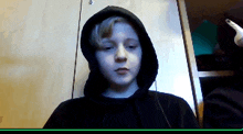 a young boy wearing a black hoodie and earbuds