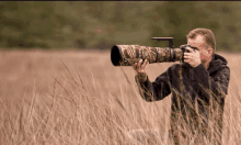 a man is taking a picture with a camera that has a camo cover on it