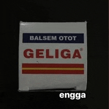 a box of balsem otot geliga is sitting on a black table .