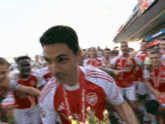 a man in a red and white jersey has a medal around his neck that says " premier league "