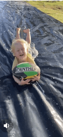 a little girl is playing with a panther ball