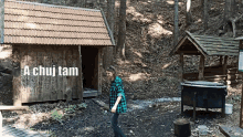 a man in a plaid shirt stands in front of a wooden building with the words a chuj tam on it