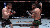 two men are fighting in a boxing ring with a manscaped advertisement in the background