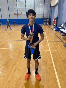 a young man holding a trophy in a gym