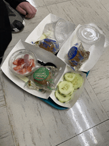 a tray of food with a green bag that says chicken tenders on it