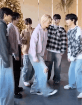 a group of young men are standing around a christmas tree .