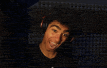 a man wearing headphones is making a funny face in front of a lego wall