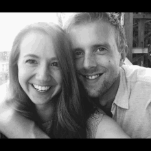 a black and white photo of a man and a woman smiling for the camera