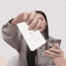 a woman is taking a picture of herself while holding a receipt