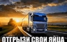 a truck is driving down a highway at sunset with russian writing on it .