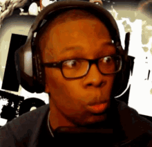 a man wearing headphones and glasses is making a surprised face