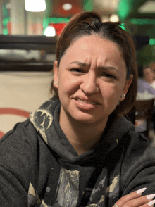 a woman wearing a grey sweatshirt with a skull on it