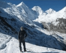 a man standing in front of a snow covered mountain