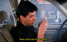 a man smoking a cigarette in a car with the words how come you 're so small
