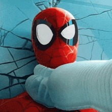 a close up of a person 's hand holding a stuffed spider-man .