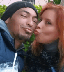 a woman is kissing a man on the cheek while holding a glass of milk