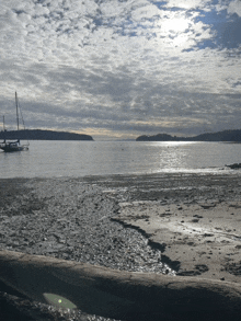 the sun is shining through the clouds on a beach