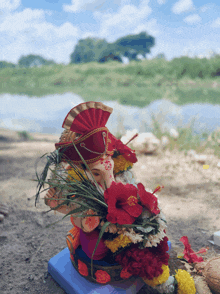 a statue of ganesha surrounded by flowers and grass