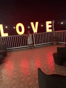 a woman is standing in front of a love sign