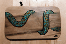 a painting of a snake on a wooden board