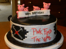 a pink floyd the wall cake with pigs on top of it