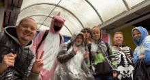 a group of people are posing for a picture and one of them is wearing a skeleton sweatshirt