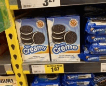 two boxes of creamy creme oreos are on a store shelf .