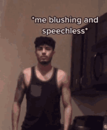 a man in a black tank top is standing in a kitchen with a caption that says " me blushing and speechless " .